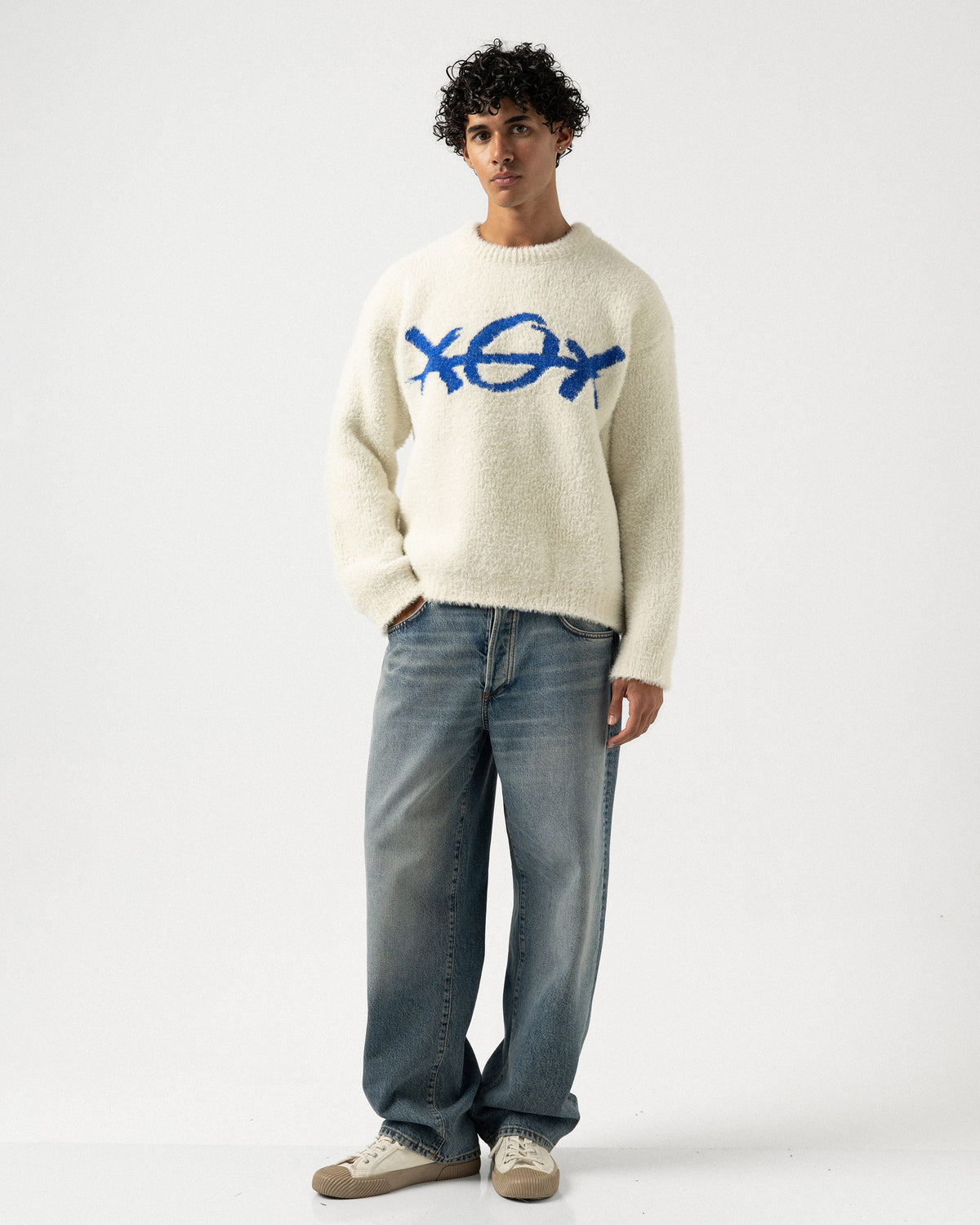 Plus Eighteen XOX ekru oversize triko kazak, mavi XOX deseni ve kot pantolonla tam boy görünüm
